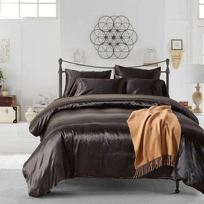 Luxury solid color silk-like 3-piece comforter bedding set on bed.