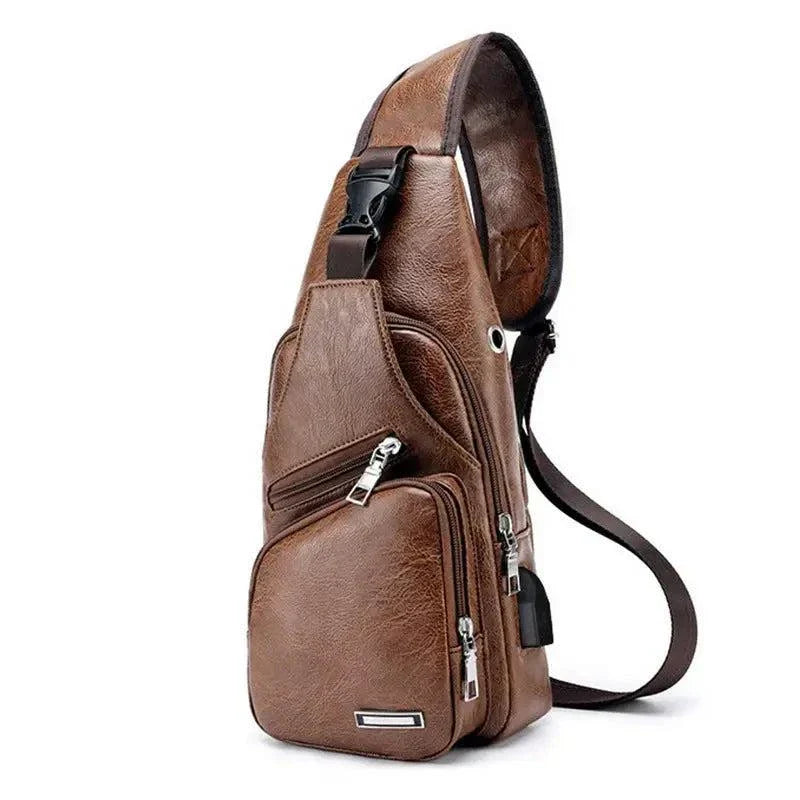 Men's brown travel cross body bag with USB charging port and adjustable strap.