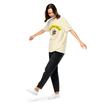 Unisex heavyweight t-shirt with woman wearing a cream-colored shirt featuring a graphic design, paired with black jeans and white sneakers.