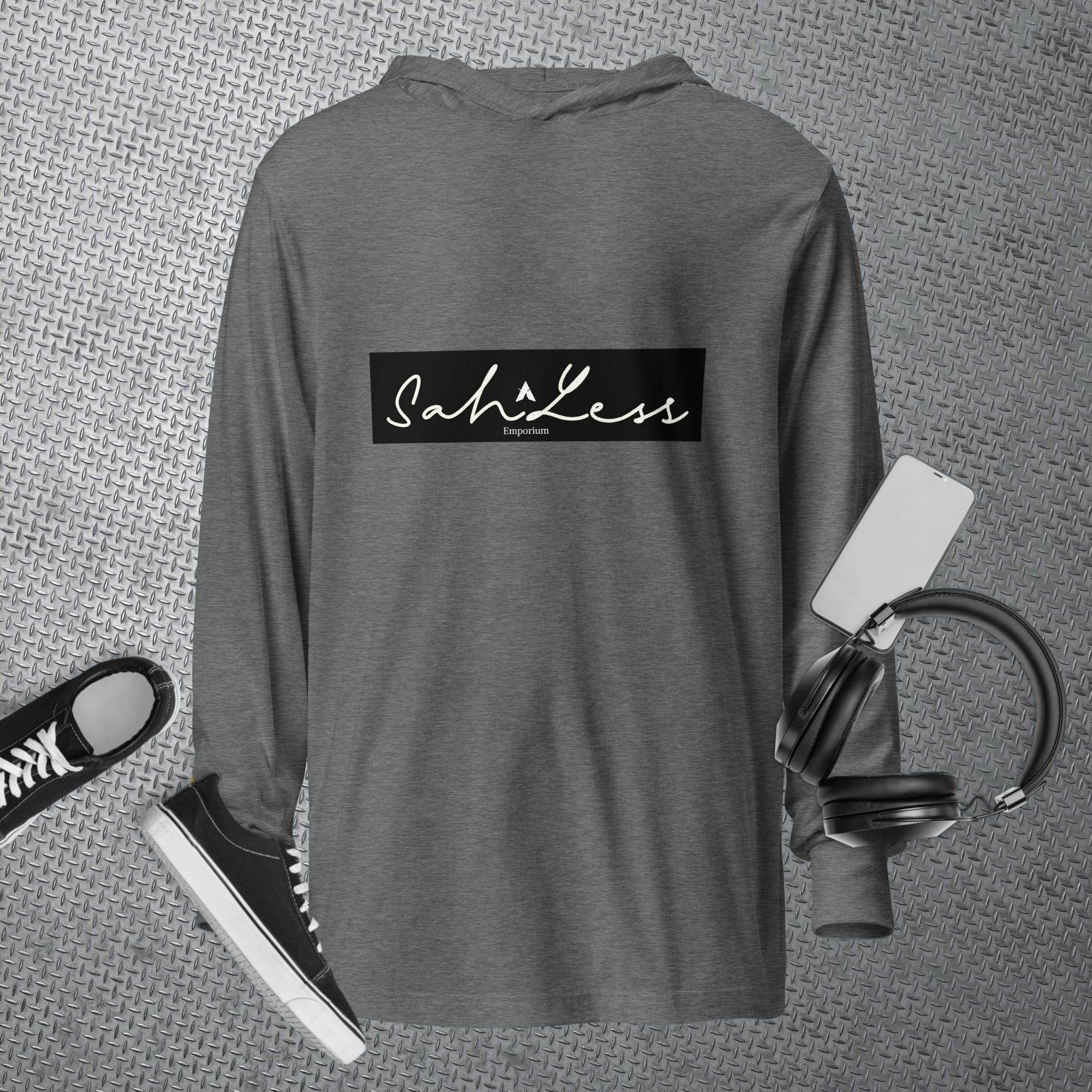 Hooded long-sleeve tee in dark gray with SahLess logo, surrounded by casual accessories.
