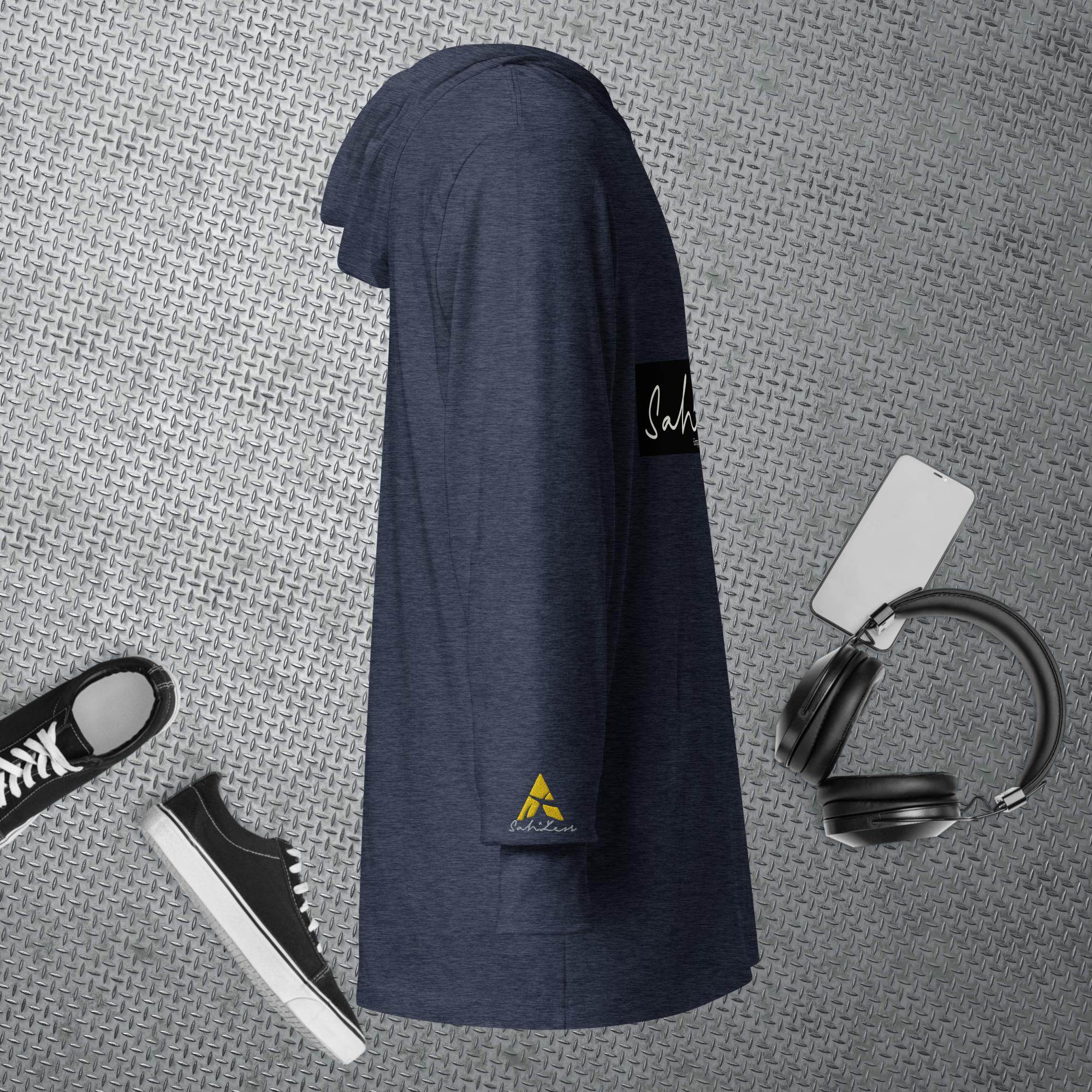 Hooded long-sleeve tee in navy blue on a textured background with sneakers, headphones, and smartphone accessories.