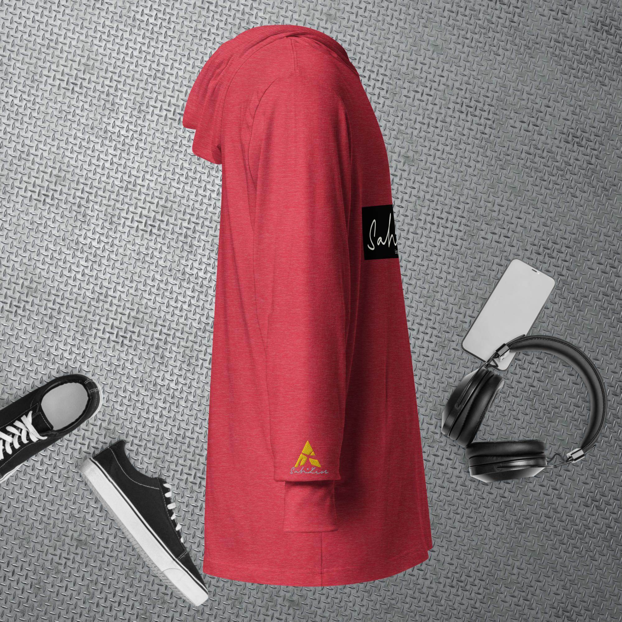 Hooded long-sleeve tee in red from SahLess Emporium, featuring a relaxed fit and adjustable hood, displayed with casual accessories.
