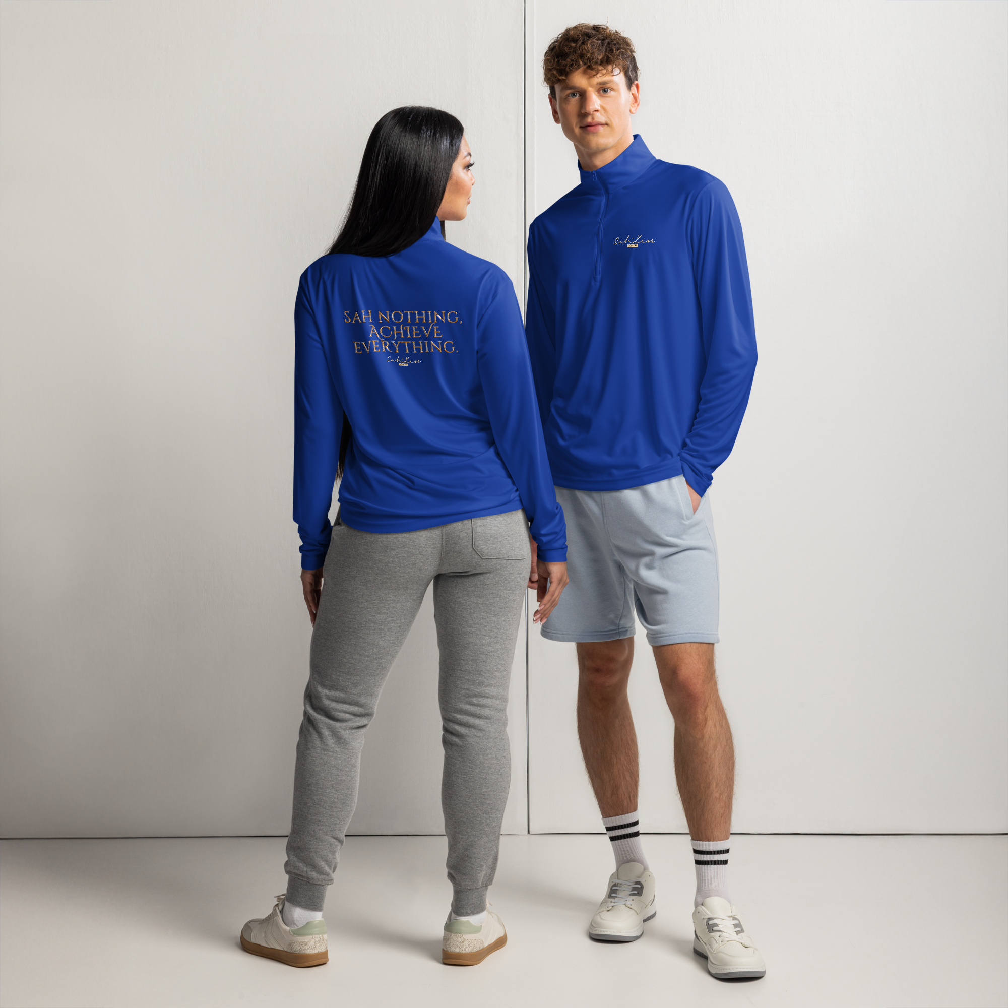 Two models wearing blue lightweight quarter-zip pullovers with moisture-wicking fabric, one facing forward and one facing backward.