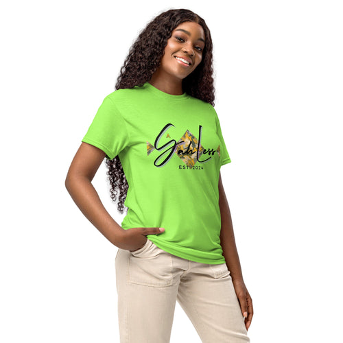 Woman wearing green DryBlend® Graphic Performance Tee with SahLess EST. 2024 logo, beige pants, smiling pose